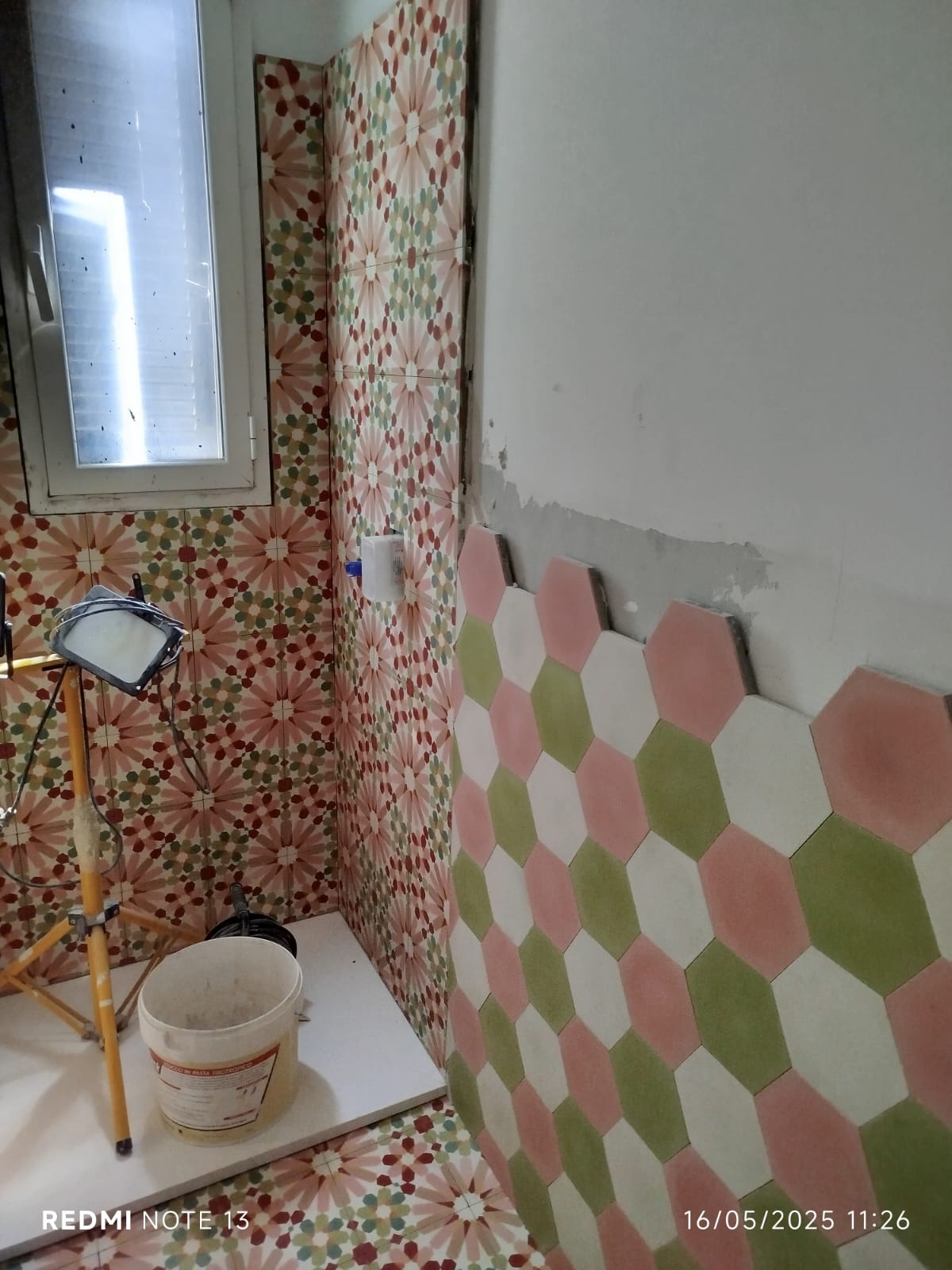Il bagno, con cementine esagonali sui toni del verde e del rosa.